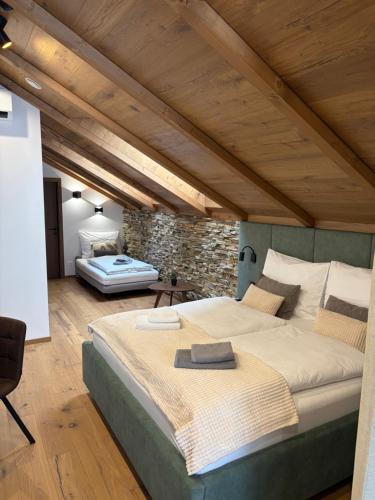 a large bed in a room with a stone wall at Vila Vento in Veľký Slavkov