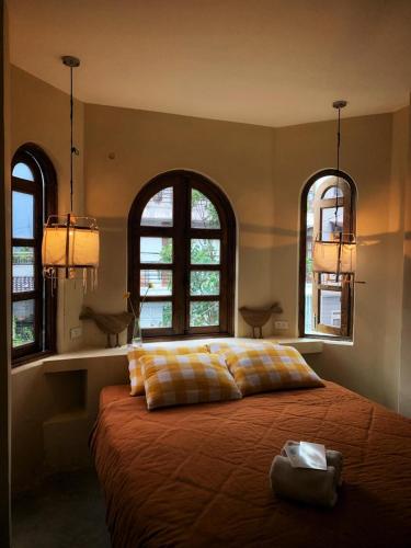 a bedroom with a large bed with two windows at Dreamershomecoffee in Xuan An