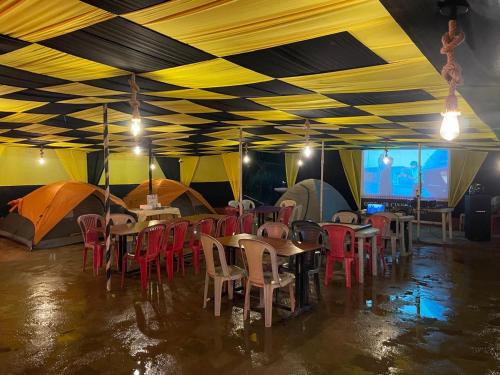 a dining room with tables and chairs in a tent at Camping At Pawana in Malavli