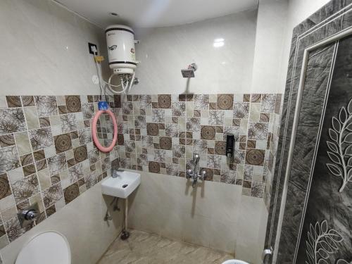 a bathroom with a toilet and a sink and a shower at Royal Paradise Guest House in Varanasi