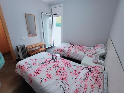 a bedroom with two beds with red and white sheets at Frente Mar in L'Escala