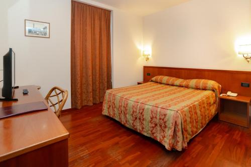 ein Hotelzimmer mit Bett und Schreibtisch in der Unterkunft Hotel Tivoli in Tivoli Terme