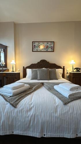 a large bed in a bedroom with two night stands at Αρχοντικό Μελλιώ Άγιος Λαυρέντιος in Agios Lavrentios