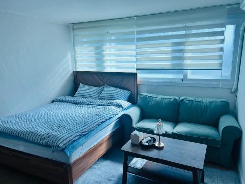 a bedroom with a bed and a couch at 하우스 The 쉼 in Suwon