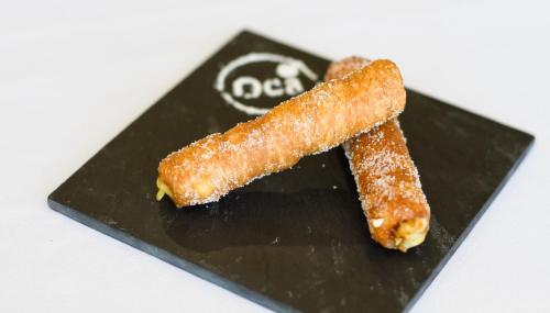 two carrots sitting on top of a black plate at Oca Puerta del Camino Hotel in Santiago de Compostela