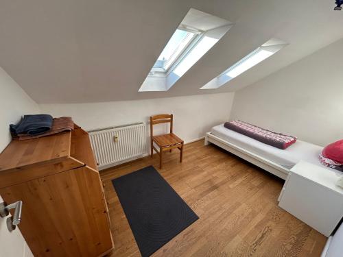 a bedroom with a bed and a chair and skylights at XL Apartment Rödermark 4SZ in Rödermark