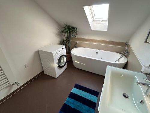 a bathroom with a tub and a washing machine at XL Apartment Rödermark 4SZ in Rödermark