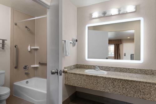 a bathroom with a sink and a mirror at Travelodge by Wyndham Banning Casino and Outlet Mall in Banning