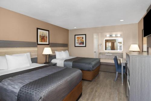 a hotel room with two beds and a kitchen at Travelodge by Wyndham Banning Casino and Outlet Mall in Banning