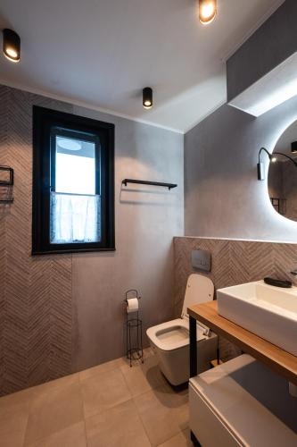 a bathroom with a toilet and a sink and a window at Къща Рустик in Belogradchik