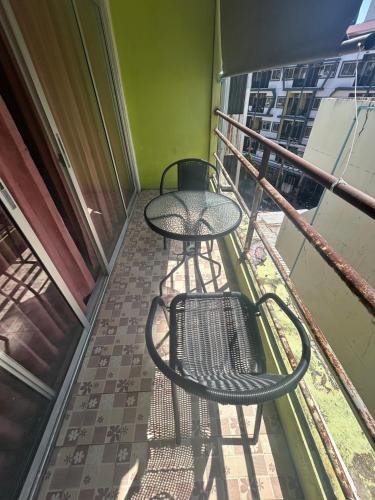 a table and two chairs on a balcony at Didim Guest House Patong in Patong Beach