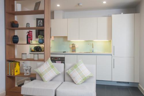 a living room with a white couch in a kitchen at Cleyro Serviced Apartments - Finzels Reach in Bristol