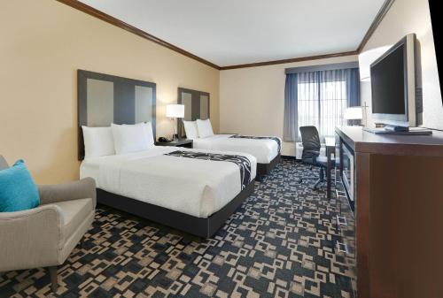 a hotel room with two beds and a desk and a television at La Quinta by Wyndham Big Spring in Big Spring