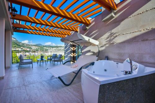 a bathroom with a tub and a table and chairs at Apart hotel KATUNJANIN in Herceg-Novi