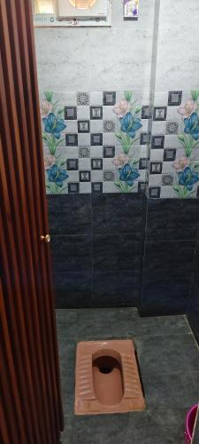 a bathroom with a brown toilet in a stall at DD Gardens in Rāmeswaram