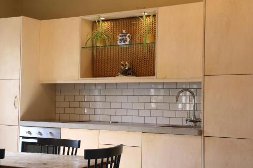 a kitchen with a table and a cat sitting on a shelf at Storytellers Cottage in Doolin
