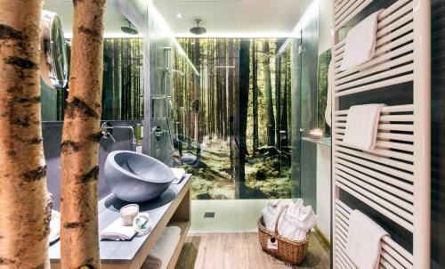 een badkamer met een douche met uitzicht op het bos bij Alp Wellness Sport Hotel Panorama in Fai della Paganella