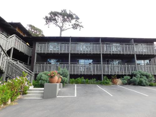 an empty parking lot with a large building at The Olympia Lodge in Pacific Grove