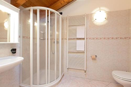 y baño con ducha, aseo y lavamanos. en Al Chestelet, en Livigno