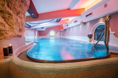 a large swimming pool in the middle of a room at Hotel Central in Gerlos