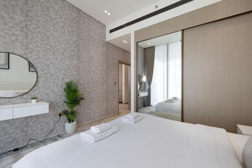 a bedroom with a large white bed and a mirror at Iconic Binghatti Royale! Private Pool in Your Balcony! 5 Star Amenities! in Dubai