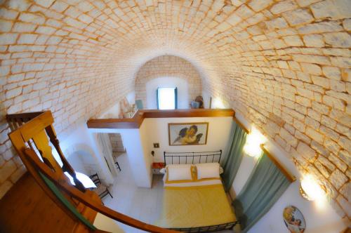 a room with a bed in a brick wall at Masseria Rosa Trulli Relais in Alberobello