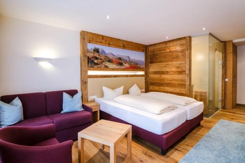 a hotel room with a bed and a couch at Hotel Central in Gerlos
