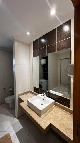 a bathroom with a sink and a tub and a toilet at Dream Royal Residence in 6th Of October