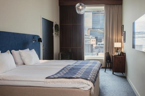 a hotel room with a bed and a large window at Home Hotel Tapetfabriken in Stockholm