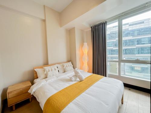 a bedroom with a large bed and a large window at Modern 1BR w Exclusive Pool Access in Lapu Lapu City