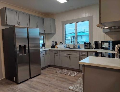 a kitchen with a stainless steel refrigerator and a window at Kekuanaoa Homestead for Queens bedroom in Hilo