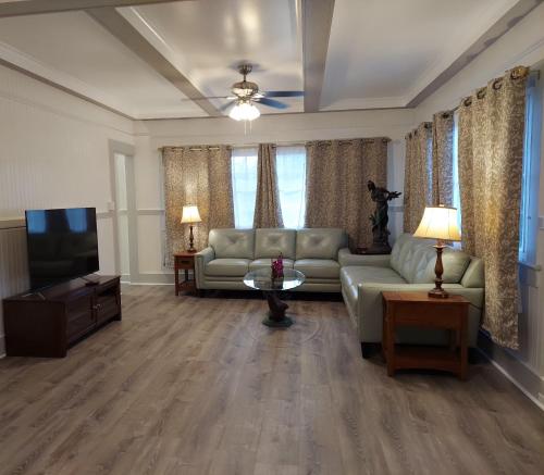 a living room with a couch and a television at Kekuanaoa Homestead for Queens bedroom in Hilo