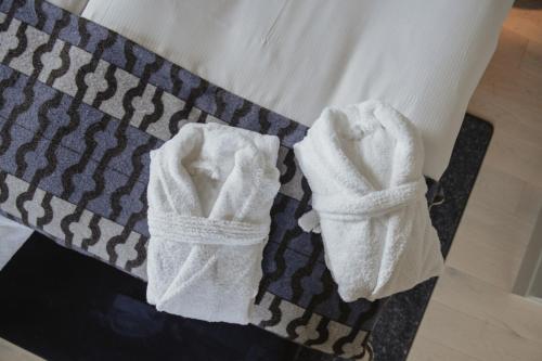 a pair of white socks sitting on a bed at Home Hotel Tapetfabriken in Stockholm