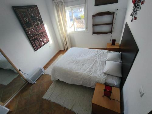 a bedroom with a white bed and a window at Atico centrico ideal en Algodonales in Algodonales