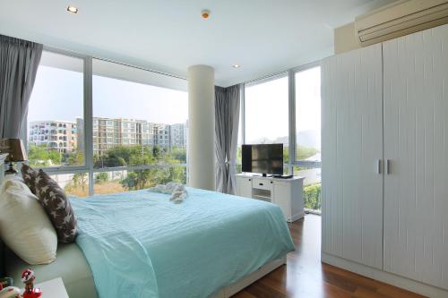 a bedroom with a bed and a large window at My Resort Huahin by MR.JAY in Hua Hin
