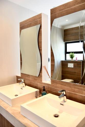 a bathroom with two sinks and a mirror at Foreshore 2 Sea View Holiday accommodation in Langstrand
