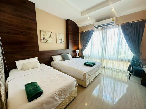 a hotel room with two beds and a window at The Villa Jomtien Pattaya By Ahmed in Jomtien Beach