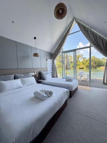 M & R 2 float house في Muang Fuang: سريرين في غرفة ذات نافذة كبيرة