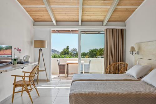 a bedroom with a bed and a desk and a table at Pacifae Hotel in Katelios