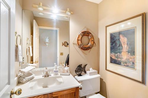 a bathroom with a sink and a toilet and a mirror at Charming Victorian Home in Okotoks Elegant Comfort Modern Convenience in Okotoks
