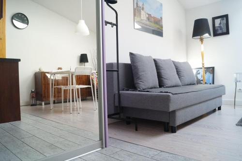 un soggiorno con divano e specchio di Apartament Ariańska a Cracovia