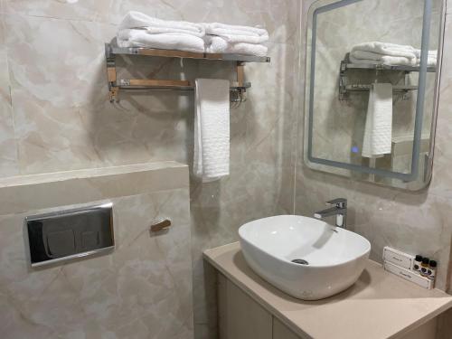 a bathroom with a white sink and a mirror at Hotel Immense Plaza in Jāmb