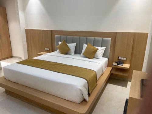 a bedroom with a large white bed with yellow pillows at Hotel Immense Plaza in Jāmb