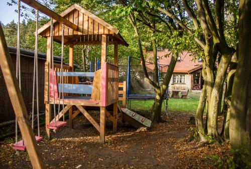 a swing set in a yard with a gazebo at Domek pod Grabami in Gdańsk