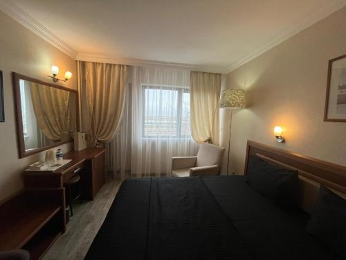 a hotel room with a bed and a desk and a mirror at Hotel Villa Marina in Bandırma