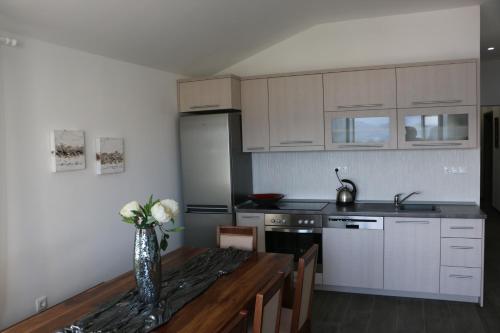 a kitchen with a vase of flowers on a wooden table at Villa Mare in Klek
