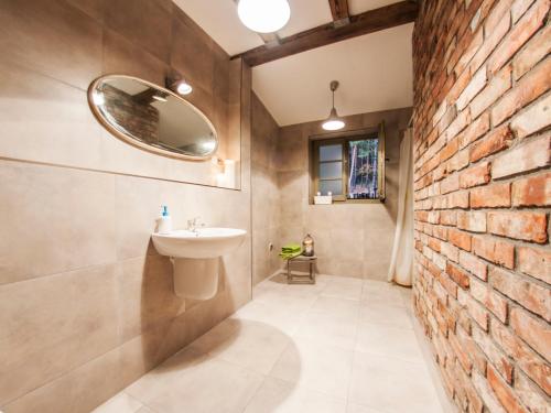 a bathroom with a sink and a brick wall at Domek pod Grabami in Gdańsk