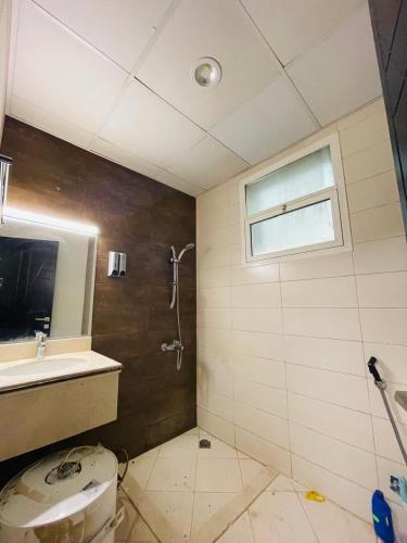 a bathroom with a shower and a toilet and a sink at AL ALKEEM HEIGHTS in Ras al Khaimah