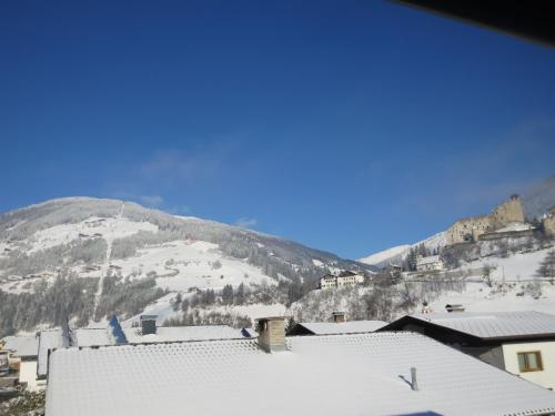 a view of a mountain with snow on the roofs of buildings at Haus Mitti in Heinfels