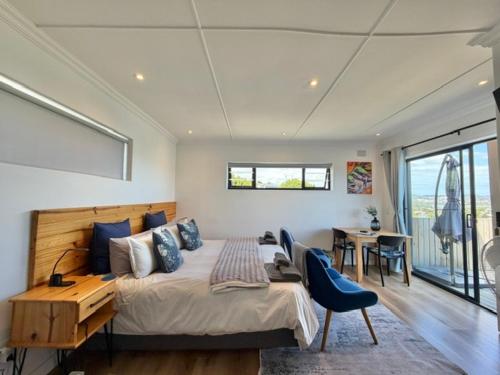 a bedroom with a large bed and a desk at De View in Knysna